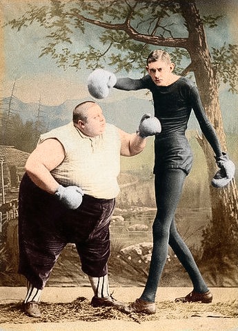Colorized photo of two boxers posing in an 1890s photo studio